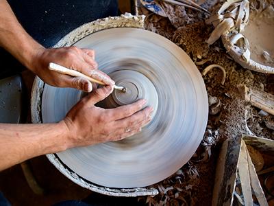 Two hands at a pottery wheel